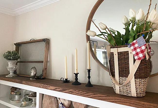 extra long mantel with basket of flowers and sifter