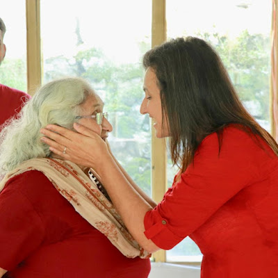 Sindhu showing care to an old lady at Inbliss Himalayas during mindfulness meditation session