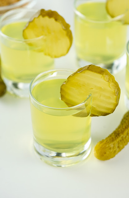 Pickle Juice Shots in shot glasses with pickle slice garnish.
