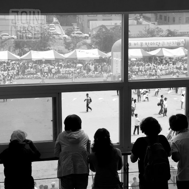 Parents watching Sports Day through a window at Bibong Elementary in Ochang, South Korea.