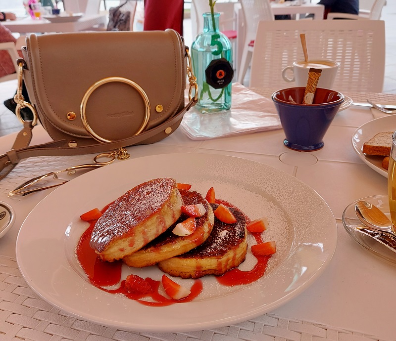 pancakes with fruit sauce on a white plate at Restaurante Flores