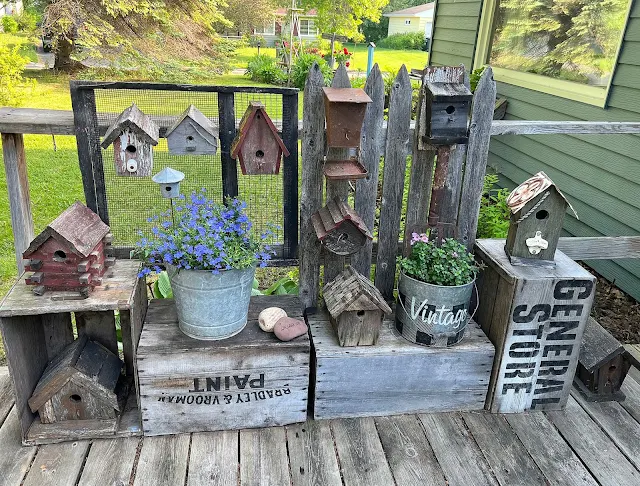 Photo of a rustic birdhouse vignette on the deck.