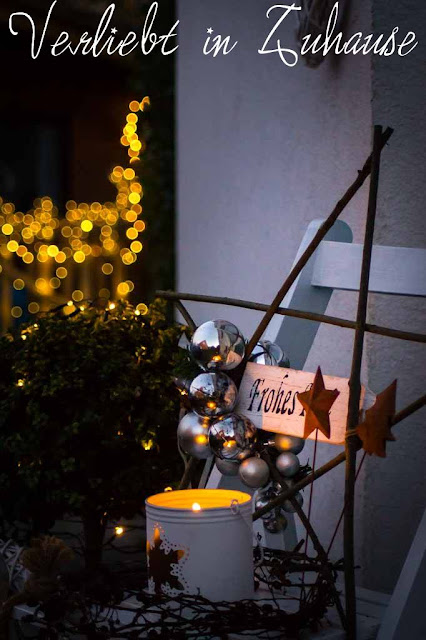 Haustüdeko im Winter zu Weihnachten mit selbst gemachten Stern aus Ästern und schönen Lichter Bokeh