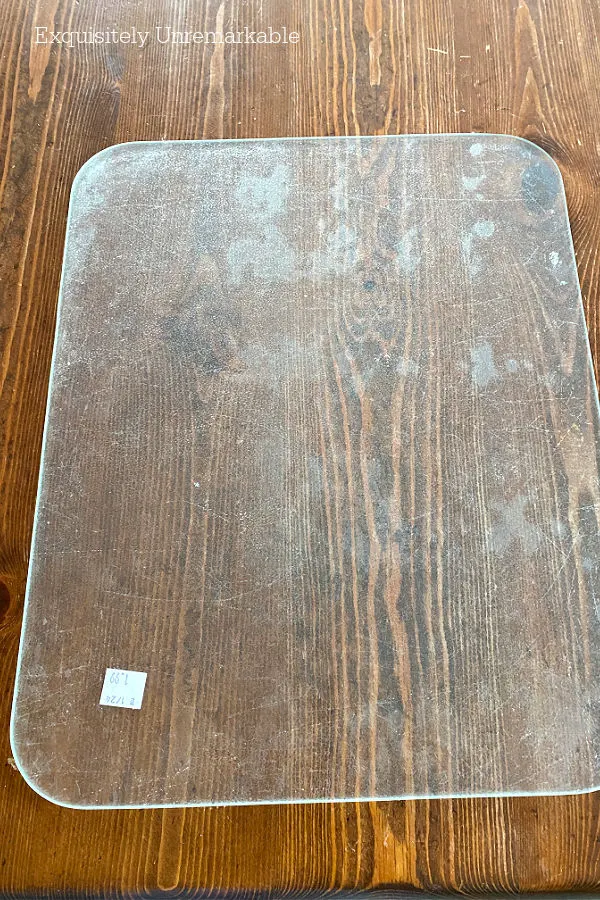 Old, thrifted glass cutting board on a table