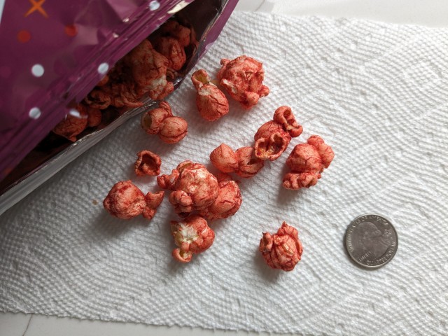 Cinnamon Sugar Flamin' Hot Cheetos Popcorn next to a quarter.