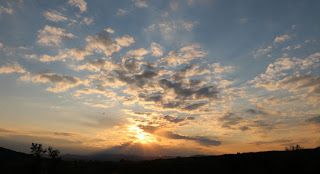 Clouds leading towards the setting sun