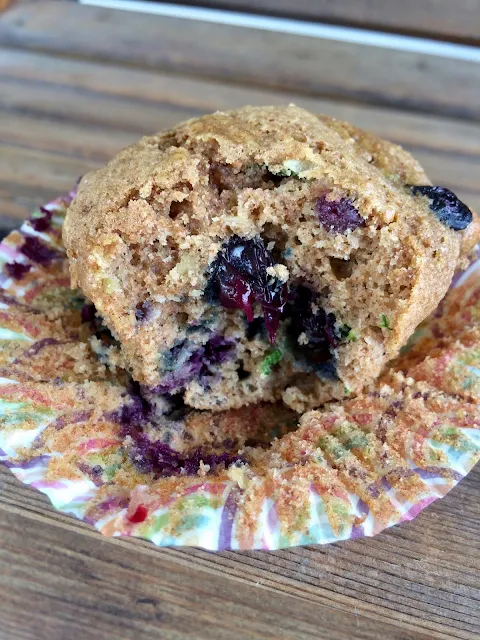Whole wheat blueberry zucchini muffin with a bite out of the side.