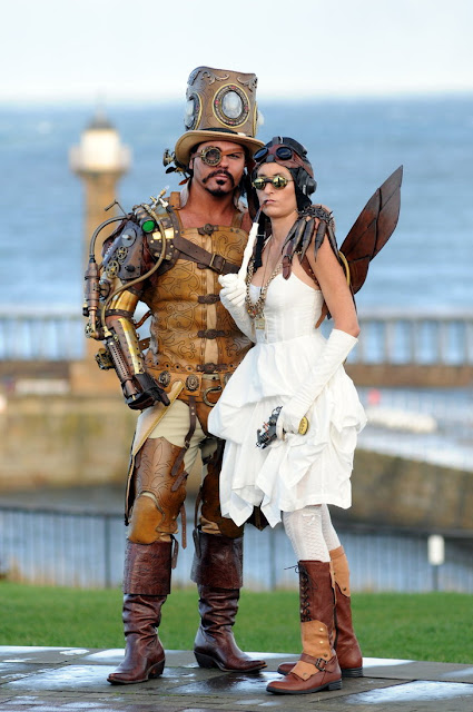 steampunk man and woman with top hat boots dress wings goggles