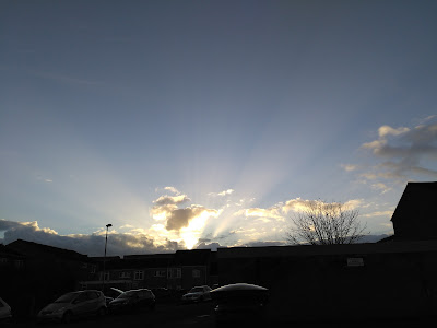 Sun shining up like God behind the clouds