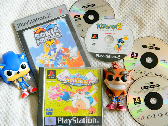 A photo showing a collection of playstation games, both discs and cased games, plus a Crash Bandicoot figure and Sonic the Hedgehog one