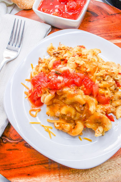 Slow Cooker Taco Mac and Cheese on a white plate with salsa on top.