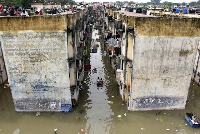 Indian people gather around a residential area that was flooded after heavy rains in Chennai on Nov. 18, 2015.