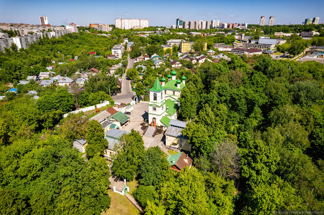 Церковь с зеленой крышей среди зеленого оазиса посреди города