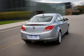 Rear 3/4 view of silver 2011 Buick Regal driving on city street