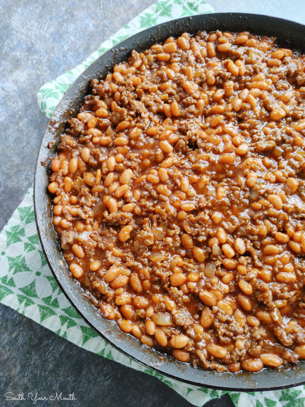 Cowboy Beans! A hearty recipe made with pork n' beans, ground beef, sausage, brown sugar and a simple sauce that's perfect for cookouts, barbeques and covered-dish affairs (finish in crock pot or on the stove).