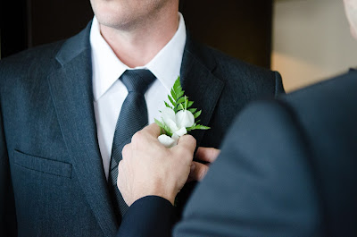 Colocando el boutonniere sobre la solapa del novio