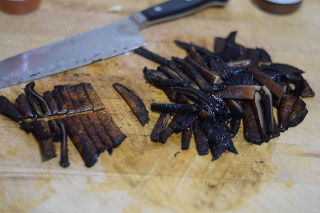 The mushrooms cut into strips on the cutting board.