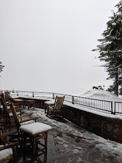 The view from the deck is completely shrouded by falling snow. It's piling up on the deck chairs and tables, too.