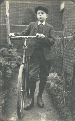 A young man with a large bicyle