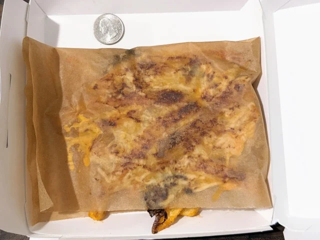 Taco Bell Grilled Cheese Nacho Fries folded in parchment paper.