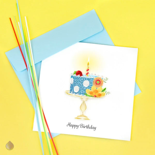 quilled birthday cake card alongside several quilling strips