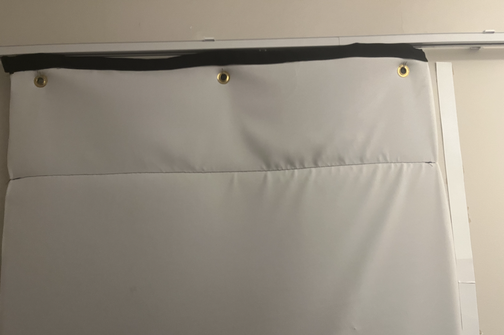 Photo of acoustic curtain on a curtain track in front of door