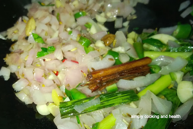 Adding  red and green chili pieces, garlic, ginger, curry leaves