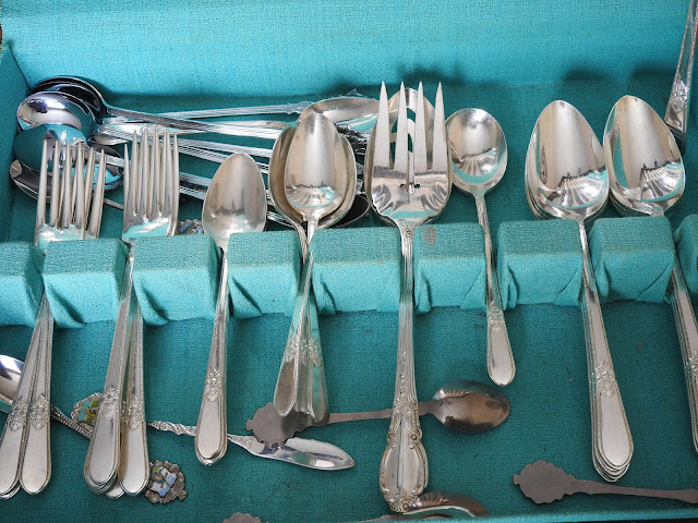 A set of vintage silver plated forks and spoons in a teal-lined box.