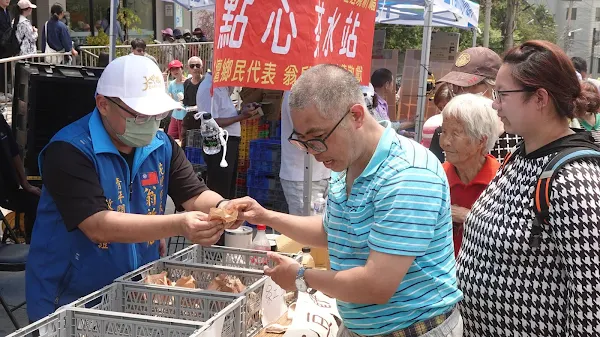 ▲花壇鄉民代表翁啟祐發送現烤紅豆餅給香燈腳補充體力。（記者林明佑攝）