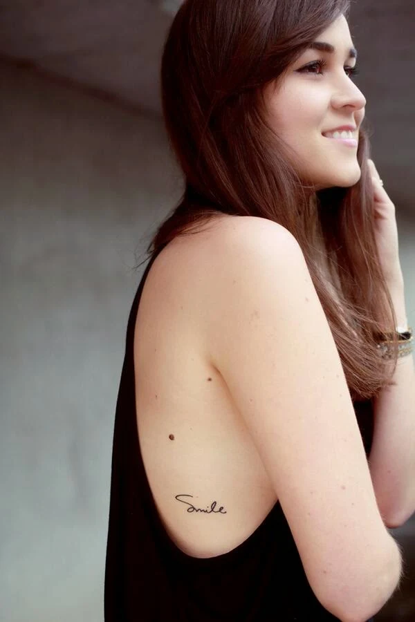 Tatuaje en las costillas que dice smile