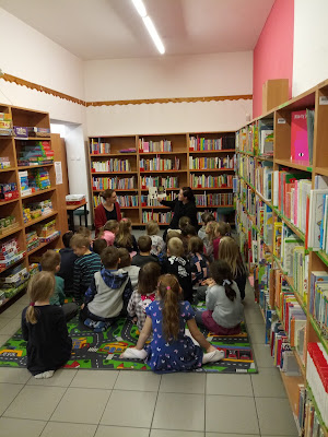 Na zdjęciu bibliotekarz czyta dzieciom książkę o Robocie Robercie