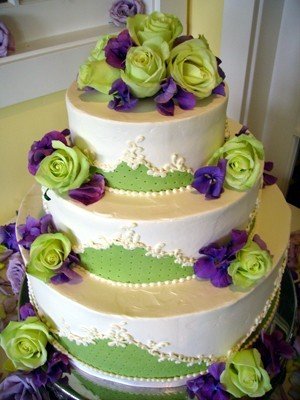 This gorgeous first wedding cake with green roses and purple flowers created