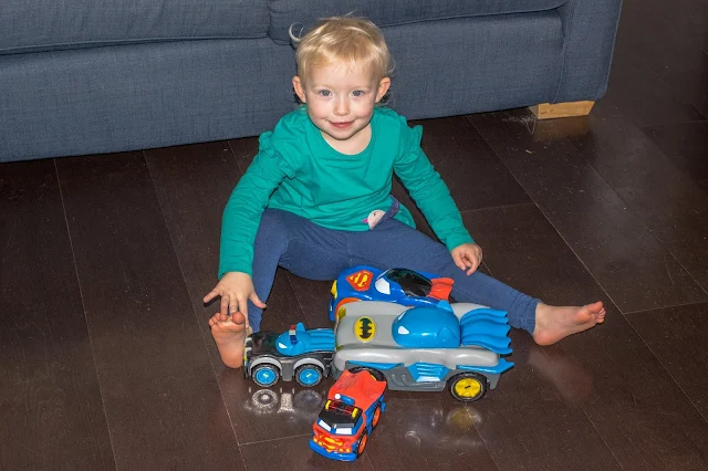 A preschooler with the Herodrive review toys in front of her