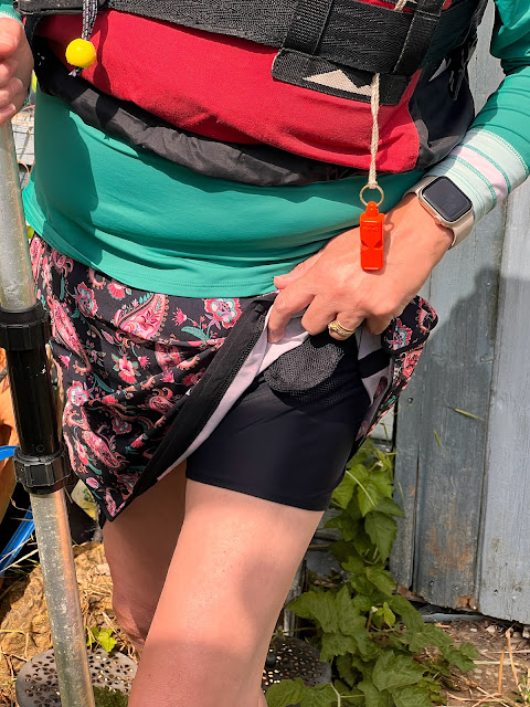 madmumof7 wearing rash vest and swim skirt from Lands' End in garden holding kayak paddle