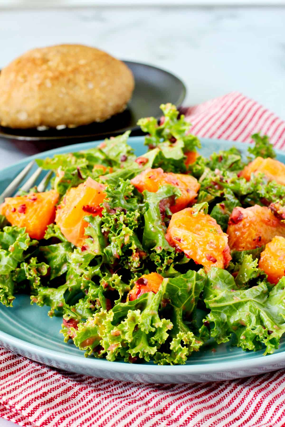 Orange and Kale Salad with and Cranberry Vinaigrette on a blue plate.