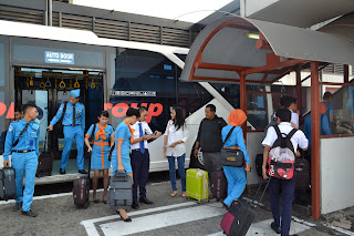 turun dari bus pengantar penumpang di bandara