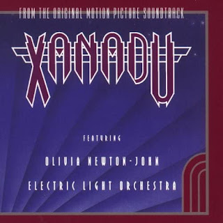 Xanadu written in pointed burgundy writing outlined in white on a purple background - just as 80s as it sounds.