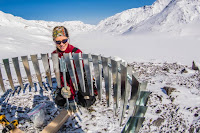 UAF researcher Anna Liljedahl puts up a wind shield around a rain gauge she installed on Jarvis Glacier. (Credit: UAF photo by Todd Paris) Click to Enlarge.