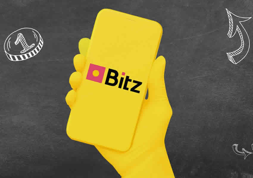 Findo escuro com um desenho de uma mão segurando um Smartphone na cor amarelo contendo a logo Bitz no centro do desenho.