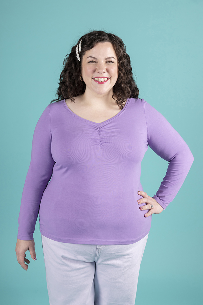 Model wearing lilac, long sleeve jersey top with ruched sweetheart neckline