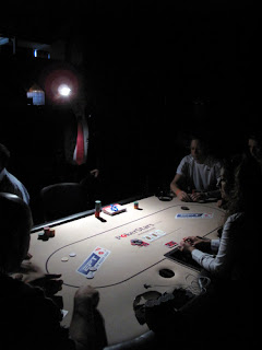 Benjo's photo of the tourney staff using flashlights to enable players to complete hands