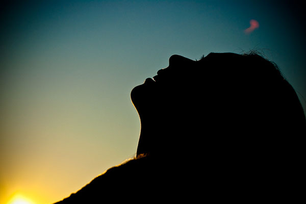 Una mujer mira al cielo.