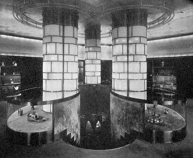 three load bearing illuminated columns above descending stairs in a 1933 store