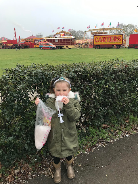 My niece eating candy floss, saying goodbye to Carters Steam Fair, wearing her hook a duck prize on her head.