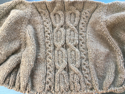 start of a cabled sweater knit from brown handspun