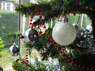 A colour photo of the baubles on my christmas tree, with my bay window in the background.