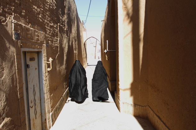 Muslim ladies walking through the narrow alleys of Yazd old town