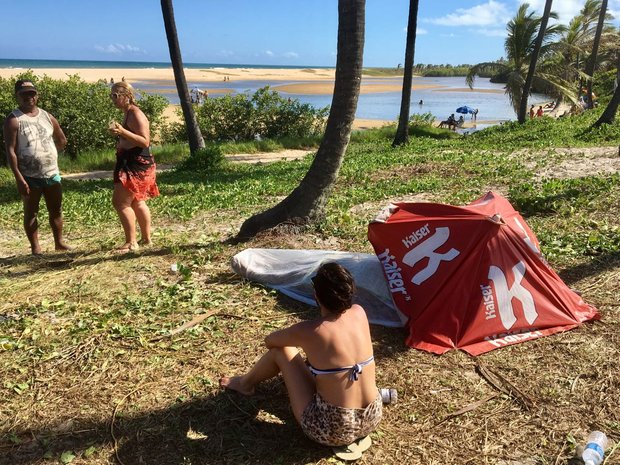 Turista vela corpo em praia de Imbassaí (Foto: Roberto Gazzi)