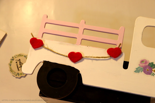 White truck with pink railing with twine  and red felt hearts