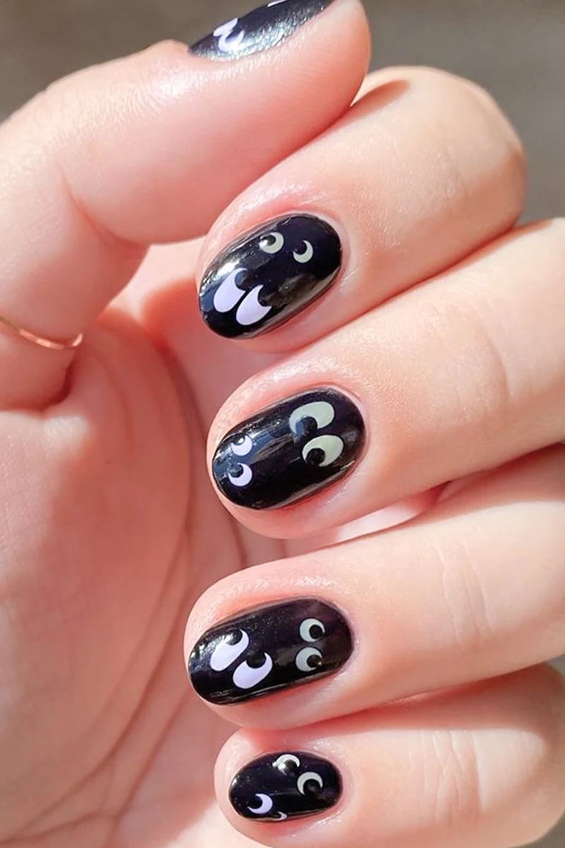 close-up of woman hand with a very cute and minimal halloween nail design